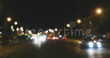 夜间交通灯散焦。蓝色的汽车灯光分成两股流，镜头向左平移